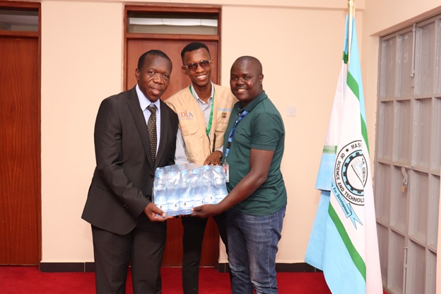 The Vice Chancellor receiving a crate of water from Lubao FM Journalists after the interviewjpg